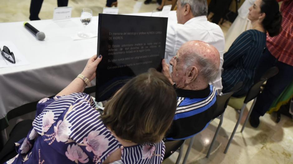 El papa de Alfredo Correa De Andréis observa la placa entregada por el Estado a la familia, en 2019.