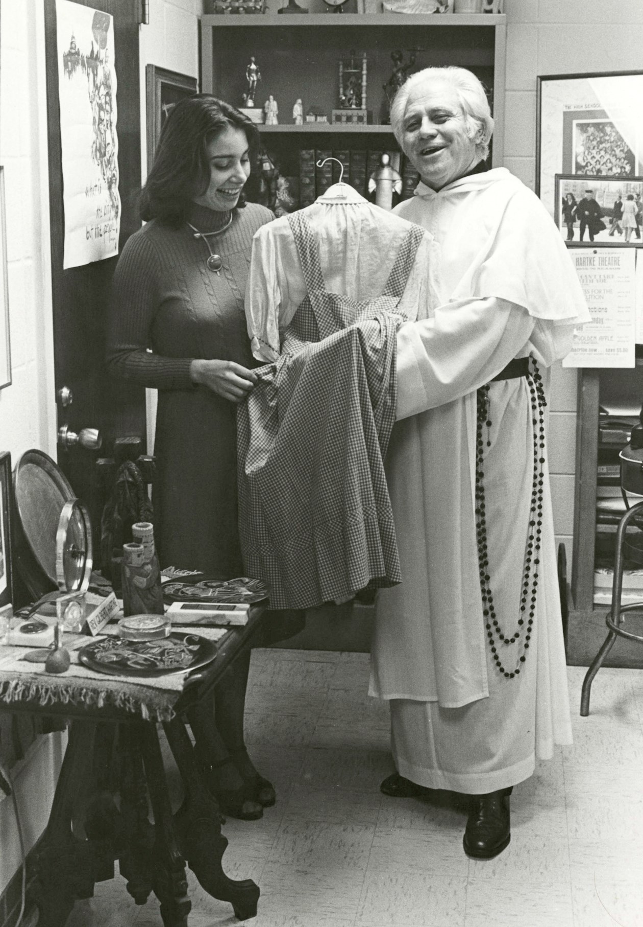 Fotografía divulgada por la Universidad Católica de América en Columbia donde aparece el padre Gilbert Hartke y la estudiante Carol Pearson mientras sostienen el vestido de Dorothy de "El mago de Oz" interpretada por la actriz Judy Garland" en 1939. 