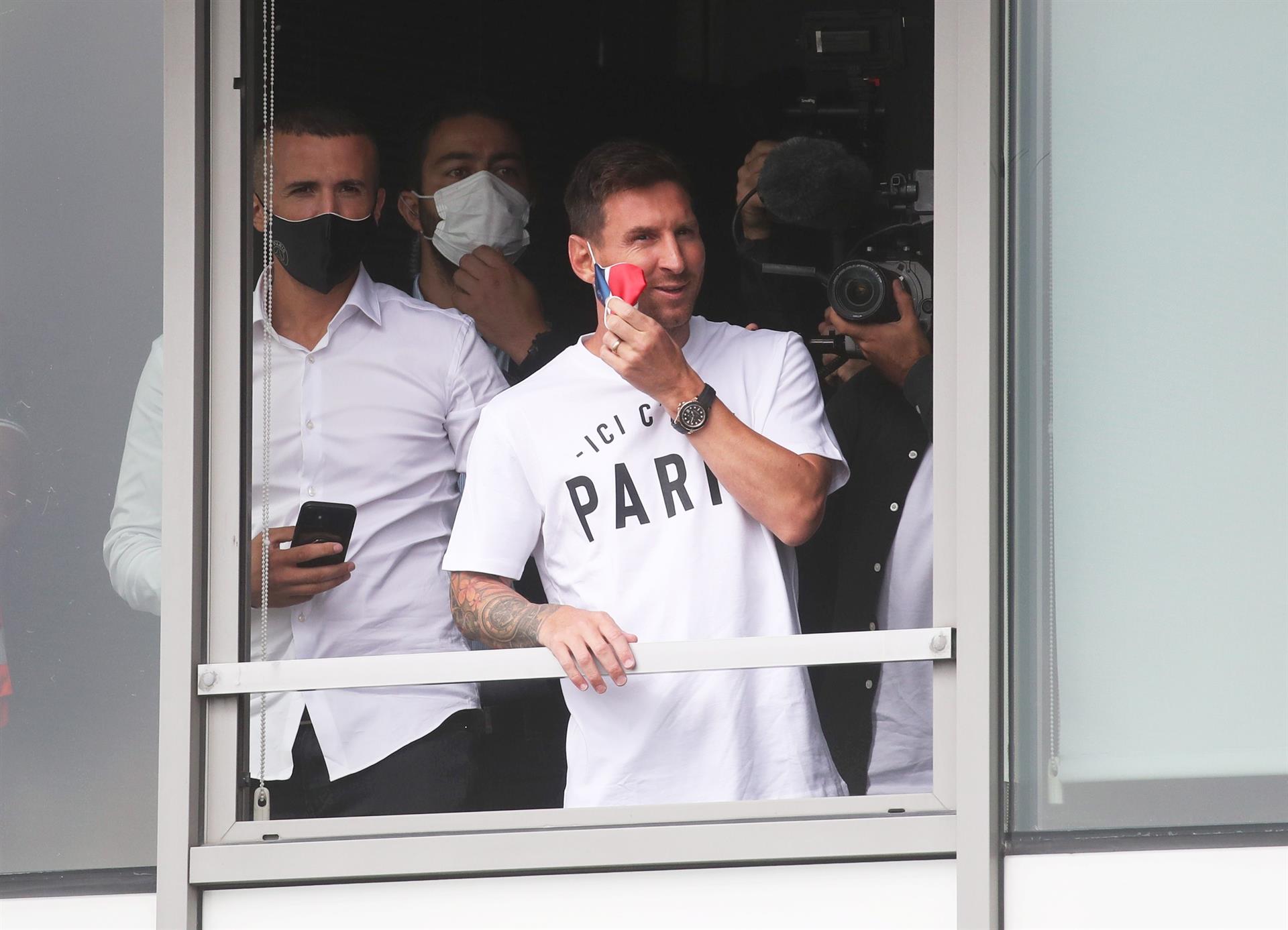 Messi se asomó por una ventaja del aeropuerto en París para saludar a los hinchas.