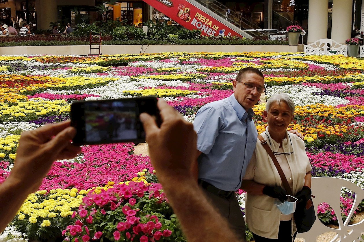 Una pareja se toma hoy una fotografía junto al tapiz de flores que realiza el Centro Comercial Santafé durante la celebración de la Feria de las Flores, en Medellín (Colombia). 