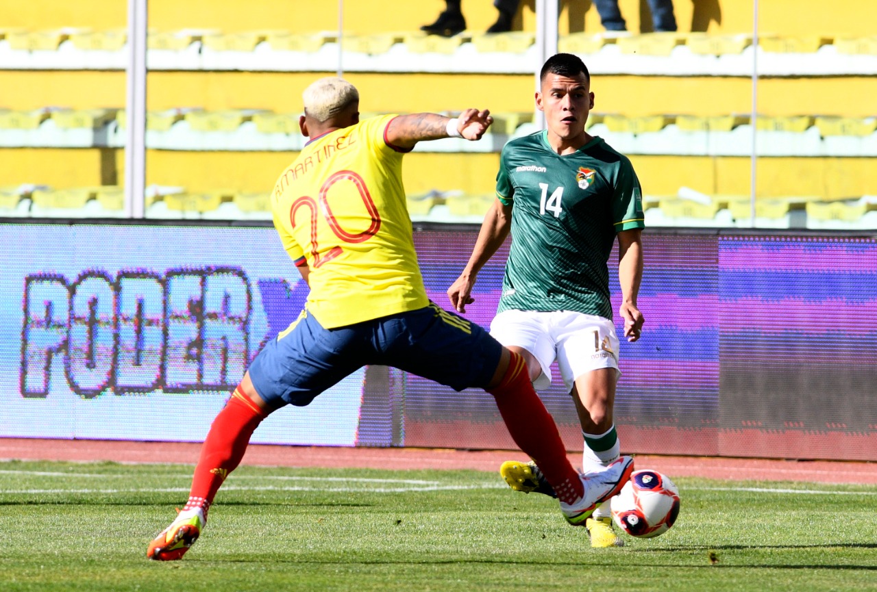 Róger Martínez intentando eludir la marca de Moisés Villaroel.