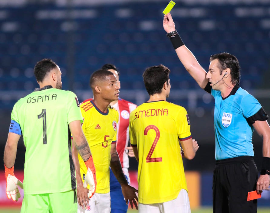 El árbitro Raphael Claus revirtiendo su decisión de tarjeta roja por amarilla a Wilmar Barrios.