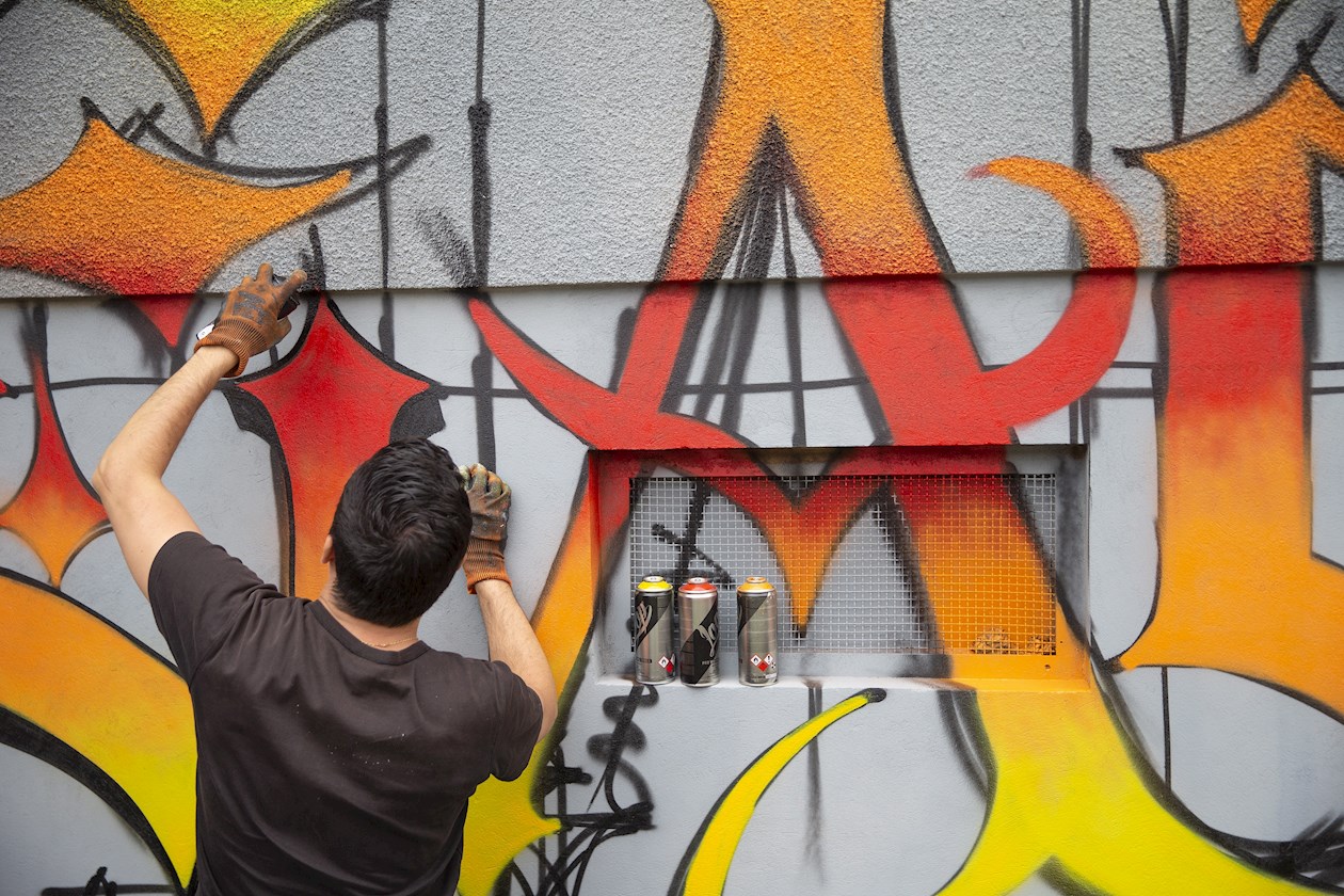 Un artista callejero trabajando en un mural en el distrito de Fontenette durante la 9ª edición de Pump Up The Jam, en Carouge, cerca de Ginebra, Suiza.