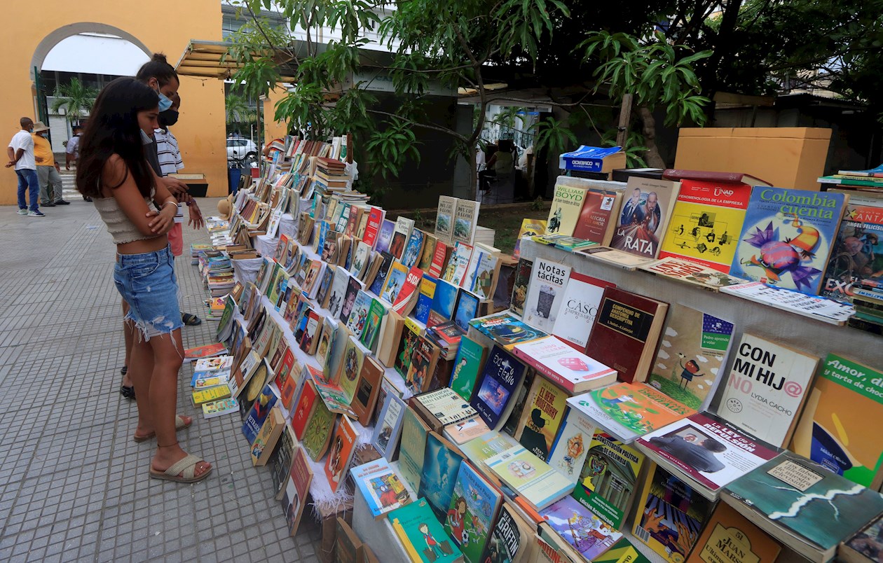 Personas observan libros en uno de los kioscos de los libreros del parque Centenario de Cartagena.