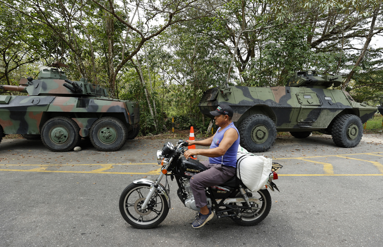 Un habitante transita frente a blindados del Ejército Nacional