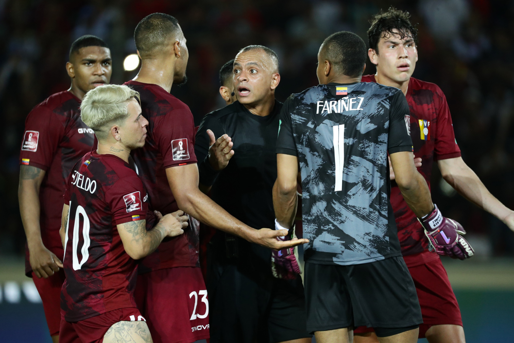 El árbitro Wilton Sampaio discute con jugadores de Venezuela tras su decisión de repetir un penalti.