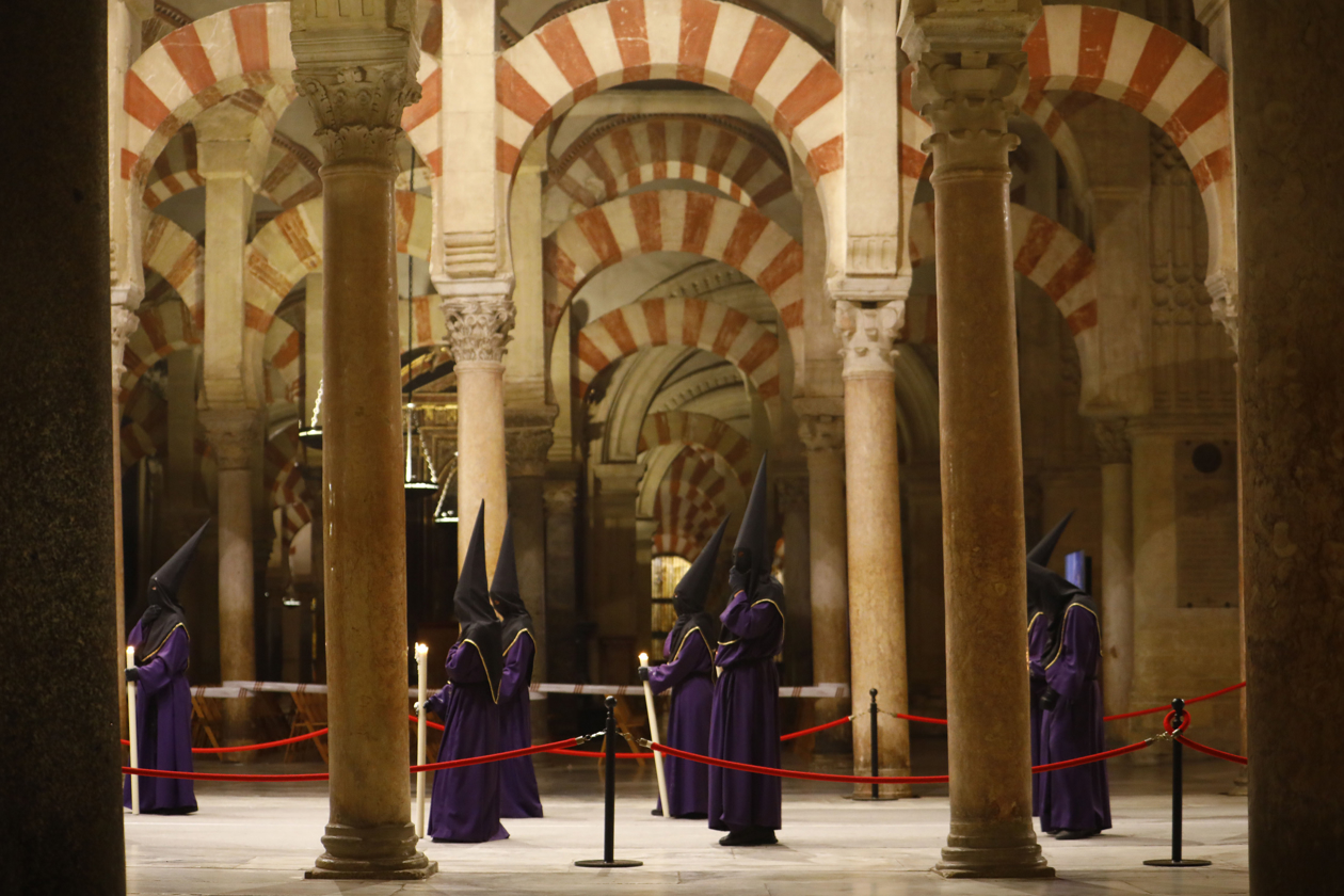Nazarenos de la Hermandad del Caído a su paso por la Mezquita-Catedral de Córdoba, hoy Jueves Santo durante su estación de penitencia. 