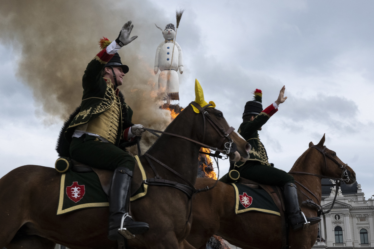 Los miembros de los gremios en uniformes históricos desfilan a caballo más allá de la figura en llamas de 'Boeoegg' en Sechselaeuten en Zúrich, Suiza.