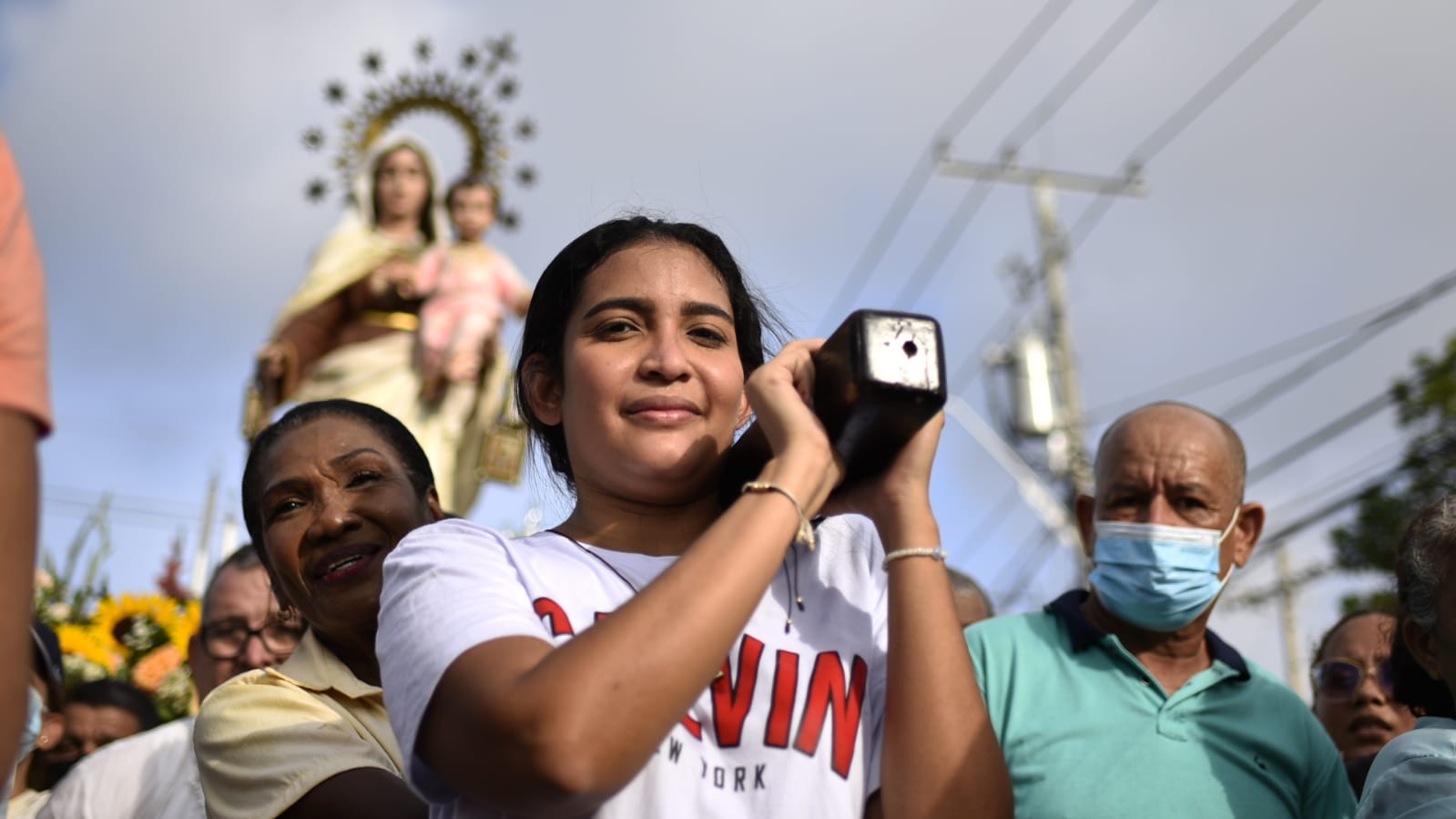 Ciudadana cargando a la virgen en el recorrido. 