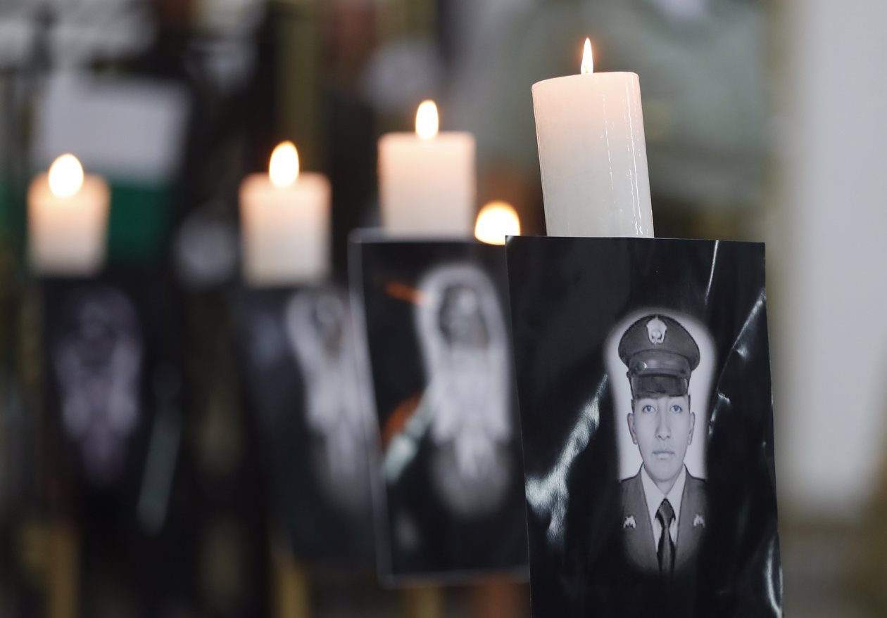 Vista de retratos durante ceremonia religiosa en honor a los policías asesinados recientemente en el país por el 'Clan del Golfo', en Cali.