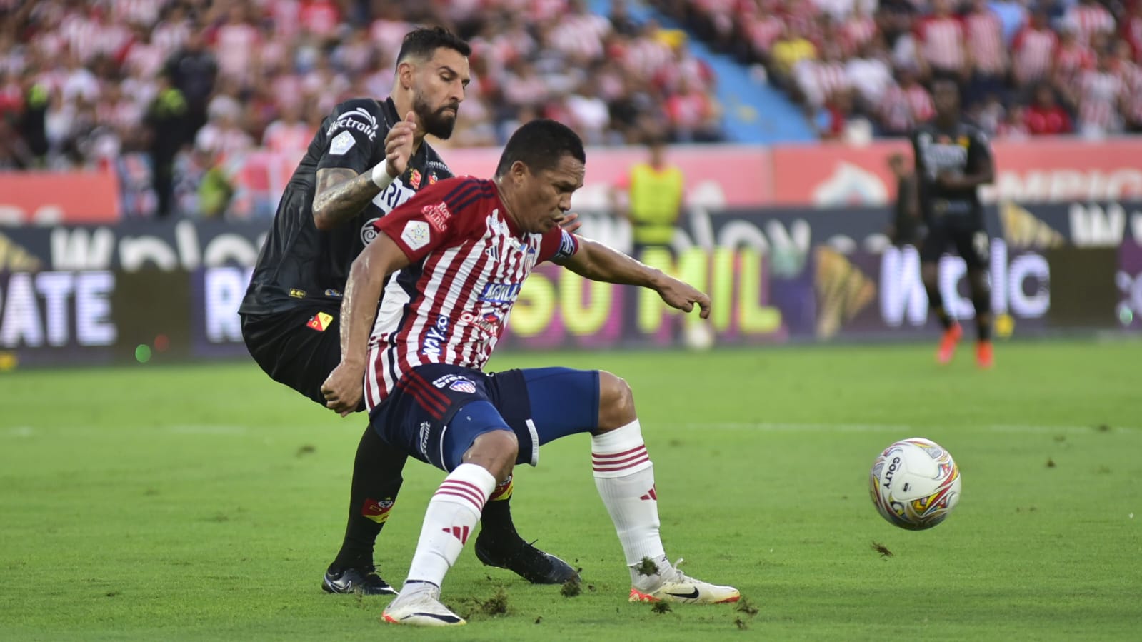 Carlos Bacca protege el balón ante la presión de José Moya. 