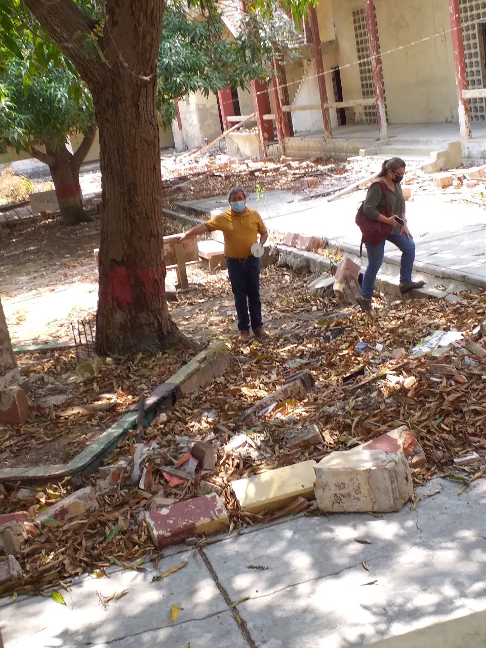 El rector Severo Ramírez y la secretaria de gestión social de educación, Lenny Puebllo Escobar, recorriendo en medio de ruinas en el interior del edificio.