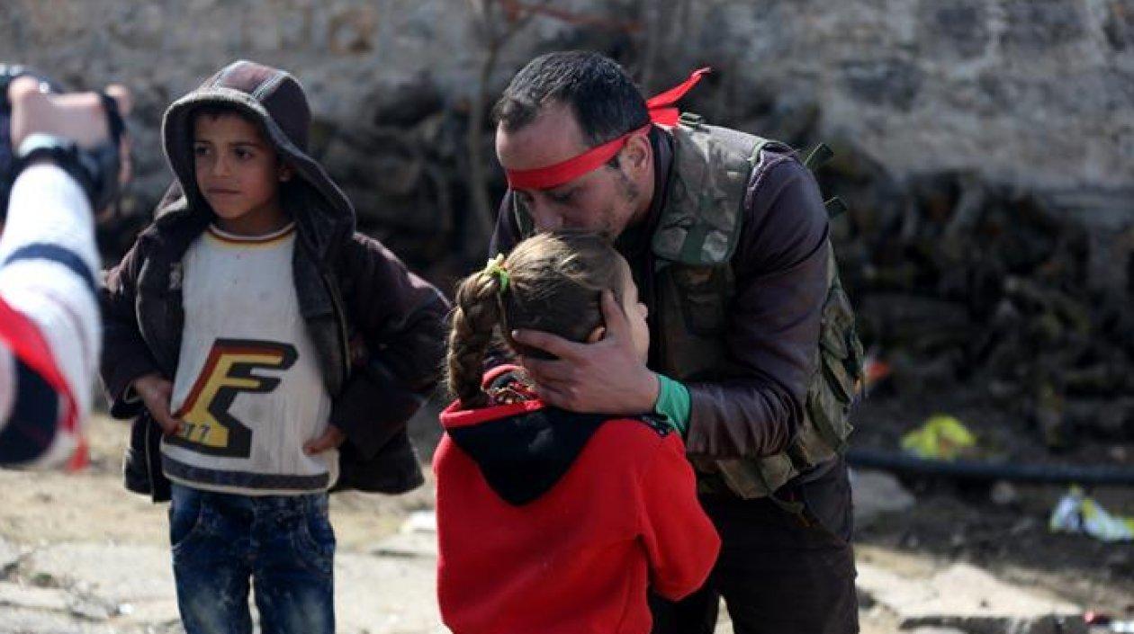 Un soldado del Ejército Libre de Siria se despide de su hija. Las cifras de niños muertos en la guerra aumentan.
