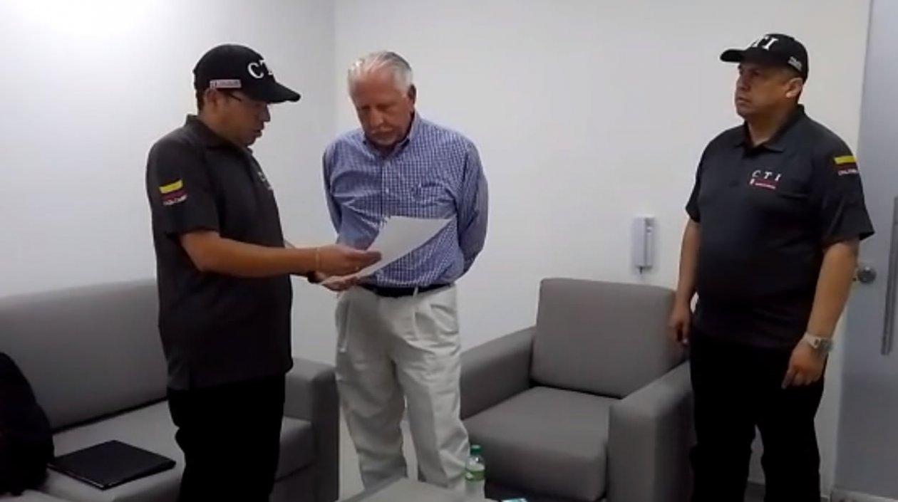 Los agentes del CTI Bogotá, leyéndole los derechos del capturado al exgerente de la Triple A Ramón Navarro.