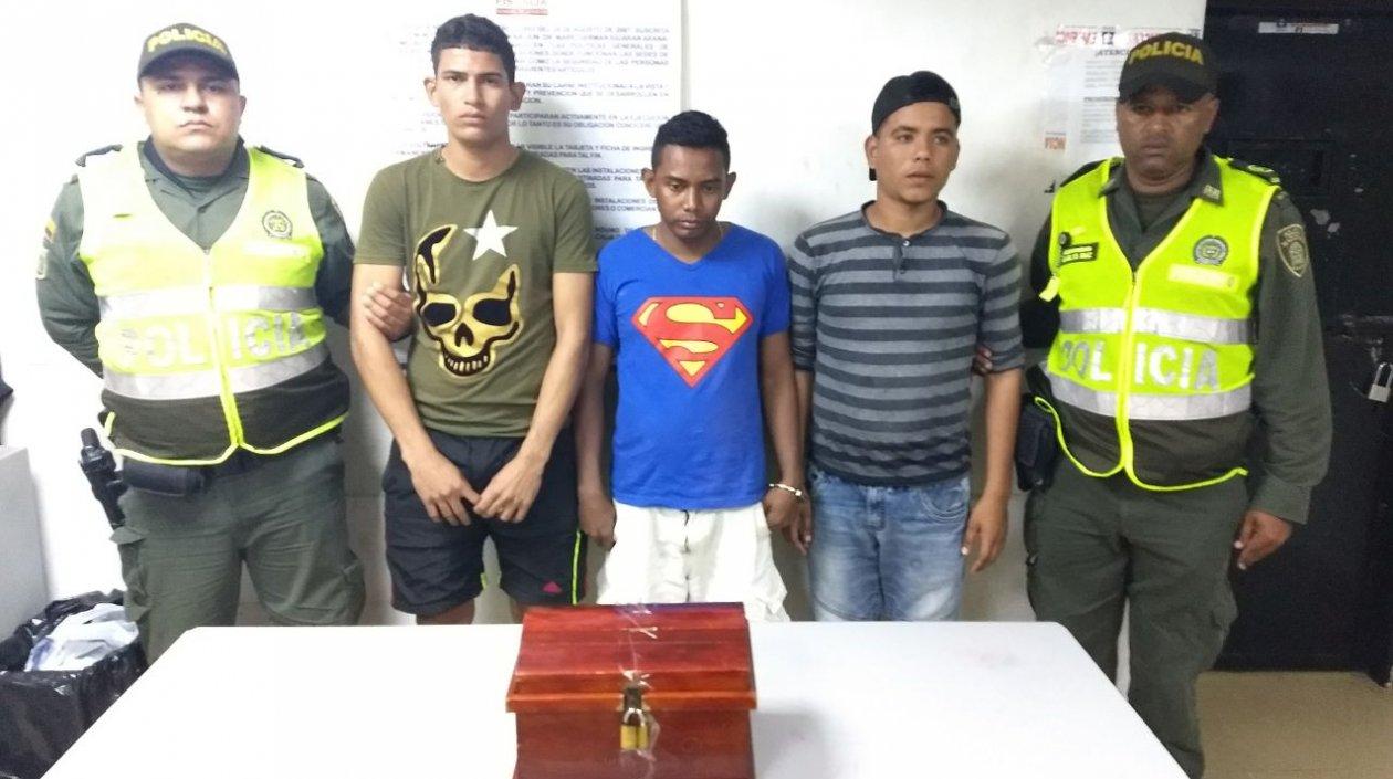 Policías muestran a los capturados con el cofre de las ofrendas de una parroquia en el barrio Las Nieves.