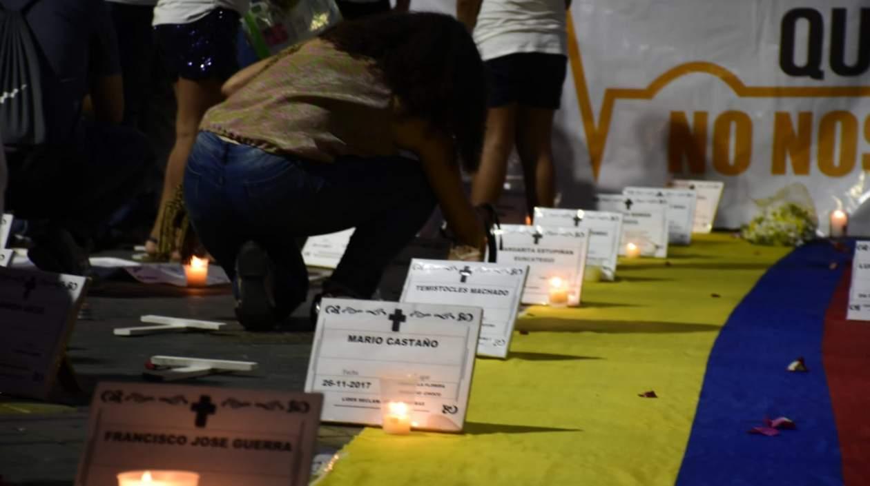 Velas encendidas, con cartelitos con los nombres de los líderes asesinados.