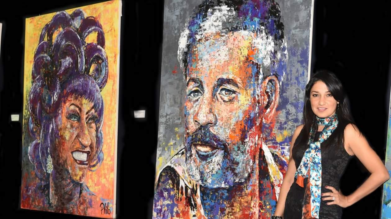 a artista plástica colombiana Dahyana Portilla donde aparece mientras posa junto a dos retratos suyos de Celia Cruz (i) e Ismael Rivera (d). Portilla acaba de inaugurar en Miami una exposición con los rostros más conocidos de la salsa