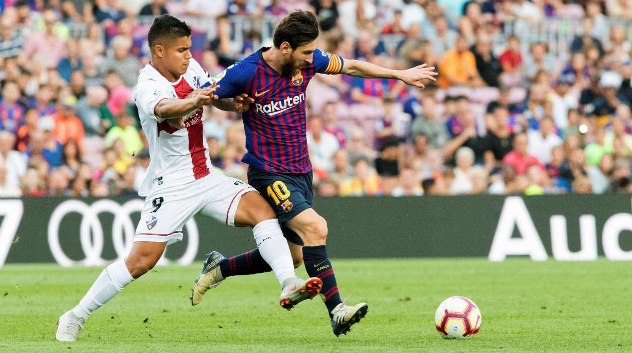 Cucho Hernández disputa la pelota con Lionel Messi
