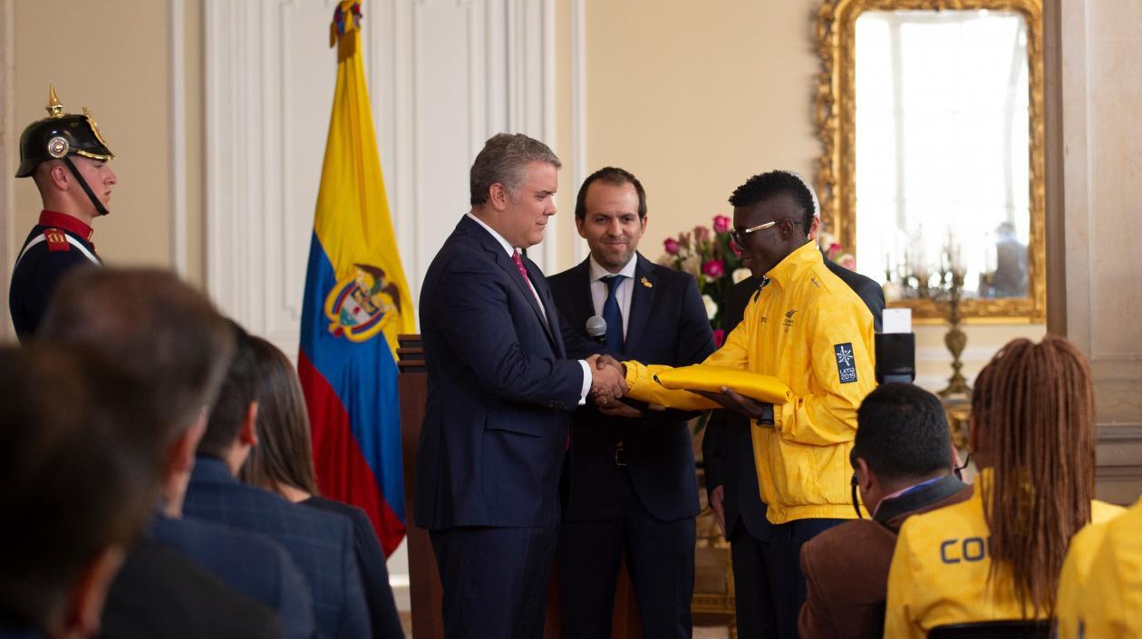 Iván Duque entrega el pabellón nacional a Yuberjen Martínez. 