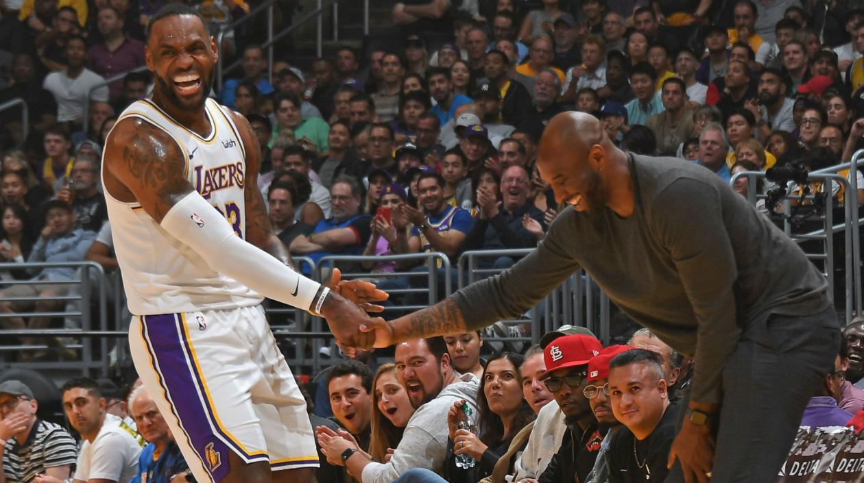 LeBron James le da la mano a Kobe Bryant durante un partido de los Lakers. 