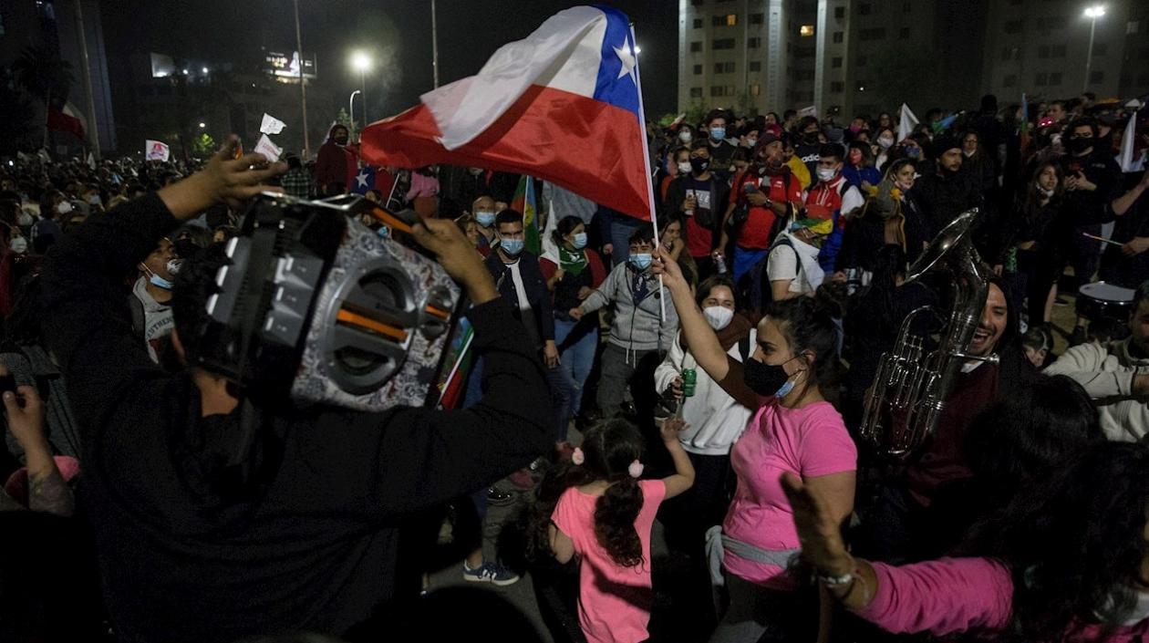 Mujer sostiene la bandera de Chile, durante los festejos del triunfo del plebiscito. 