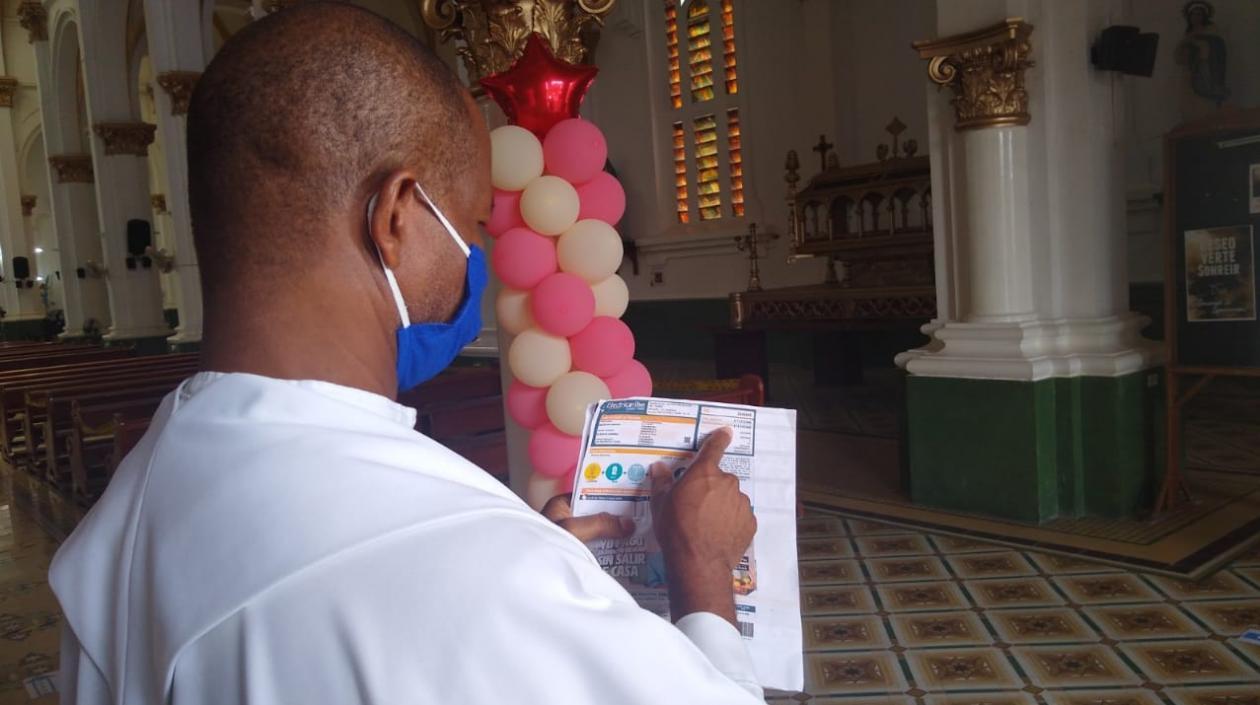El sacerdote Roberto Rodríguez Padilla, párroco de la Iglesia de Chiquinquirá, muestra el recibo.