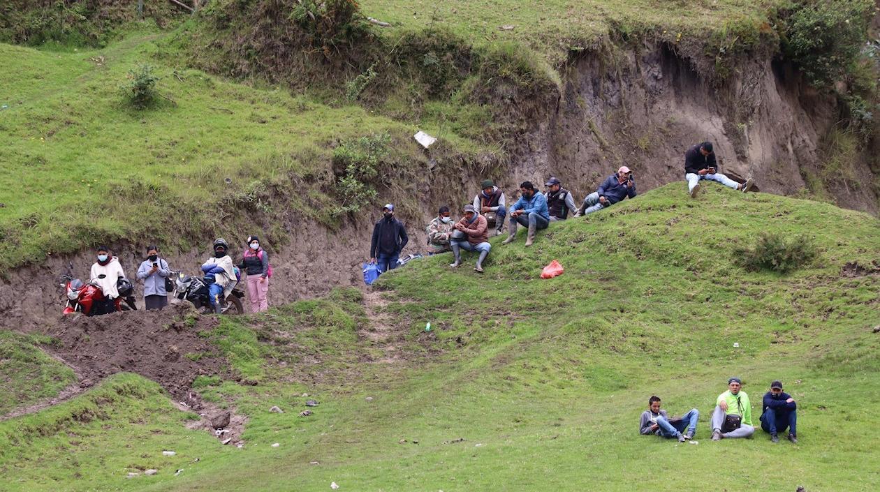 Migrantes venezolanos descansan en una de las colinas junto al cauce del fronterizo río Carchi.
