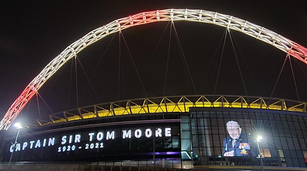Estadio de Wmbley encendió sus luces en honor al capitán Tom Moore. 