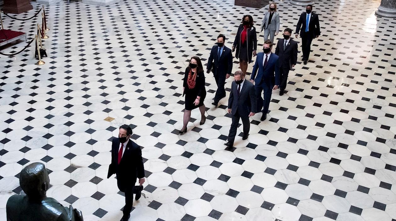 Encargados de la acusación a expresidente Donald Trump caminan por el National Statuary Hall.
