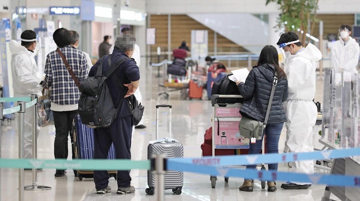 Personal del aeropuerto internacional de Incheon, al este de Seúl, comprueban que los pasajeros que llegan, lo hacen con una PCR negativa. 