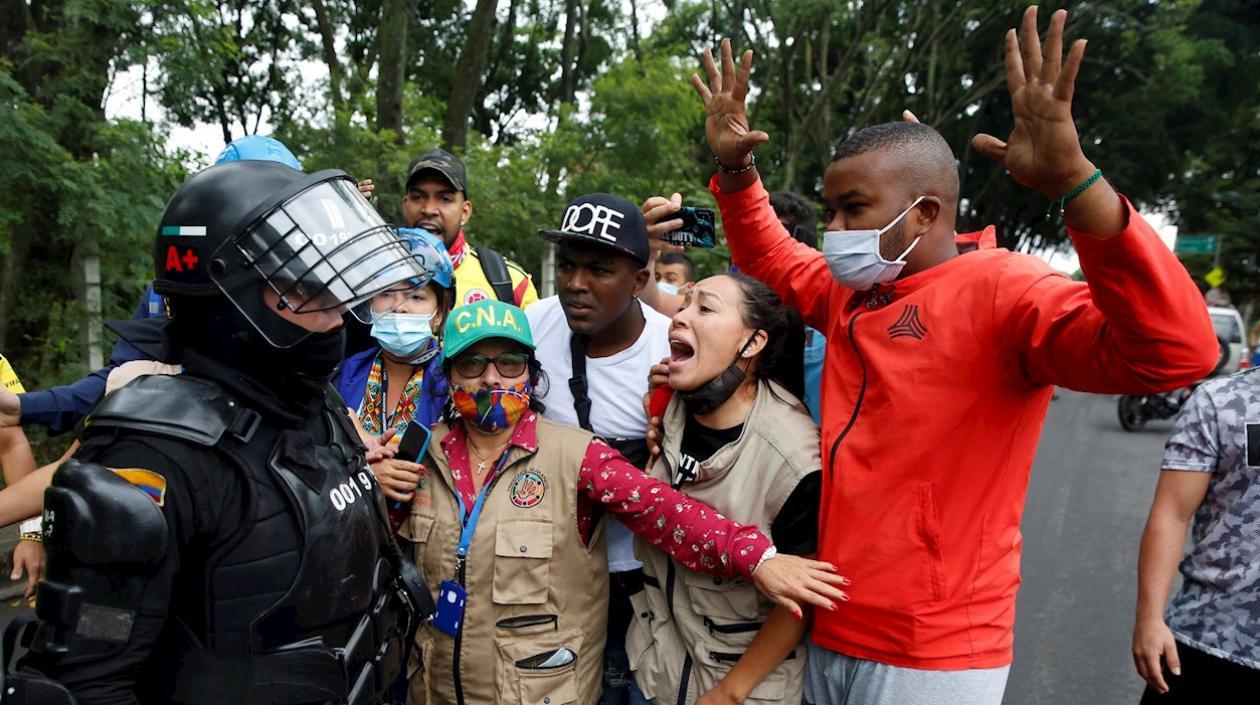 Un efectivo del Escuadrón Móvil Antidisturbios (ESMAD) de la Policía y  manifestantes, en Cali (Colombia). 