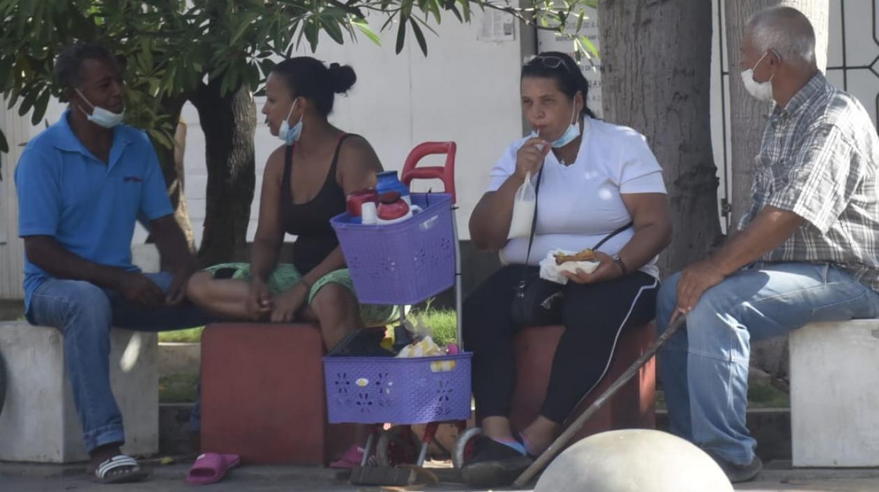 En un lugar de Barranquilla, cuatro personas conversan sin distanciamiento.