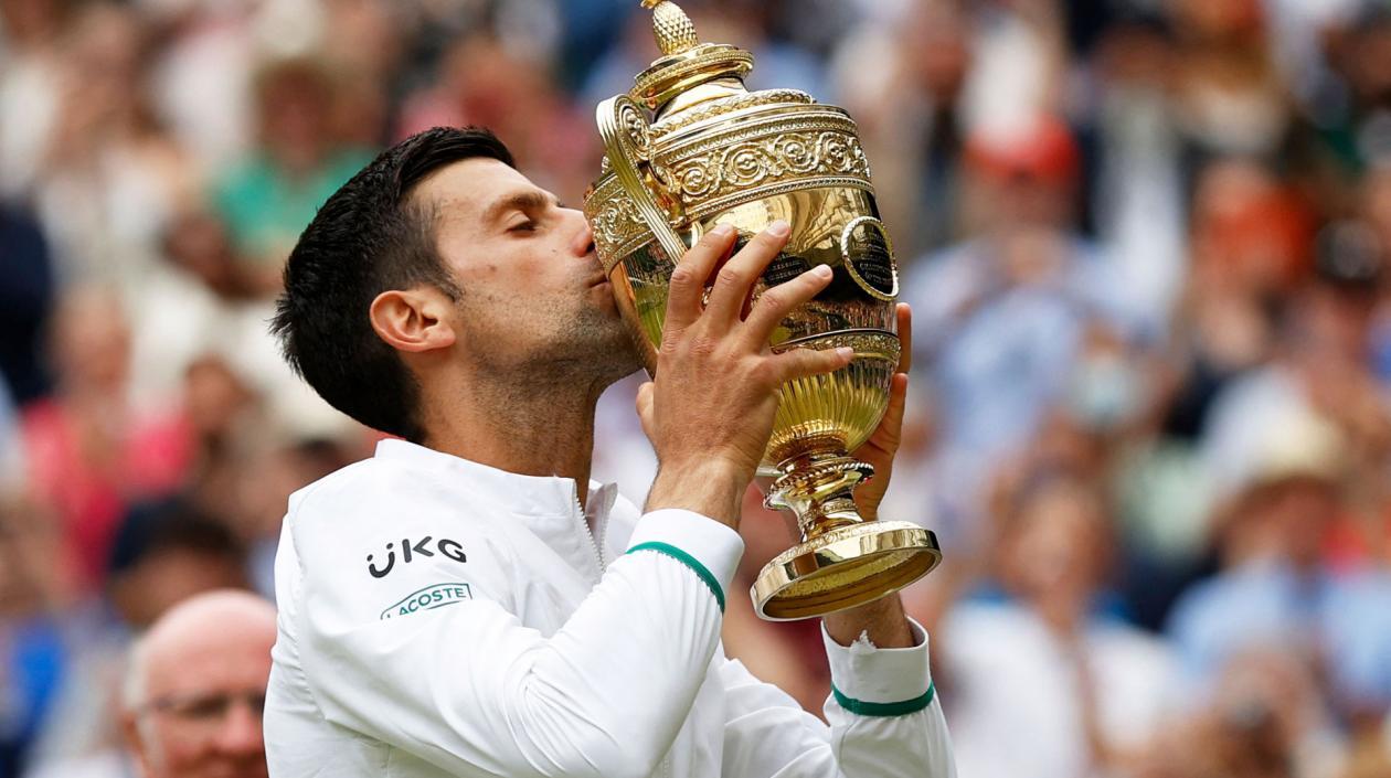 Novak Djokovic besa el trofeo de campeón de Wimbledon.