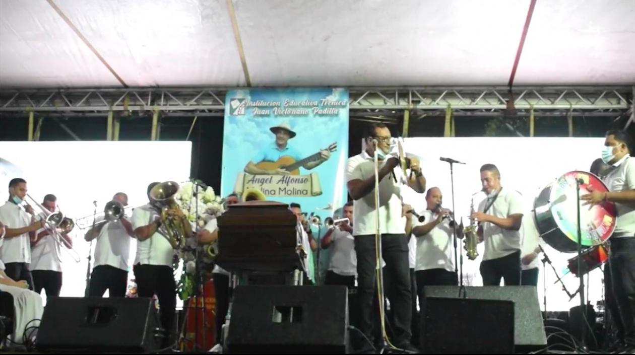 El féretro en el centro de la tarima y la banda El Sindicato interpretando canciones de 'Poncho' Molina
