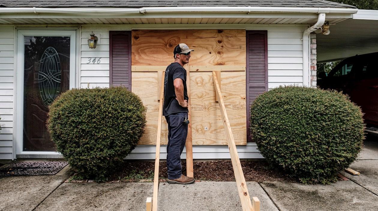 Kirby Plaisance ayuda a asegurar la casa de sus padres mientras se preparan para la llegada del huracán Ida en St. Charles Parish, Louisiana.