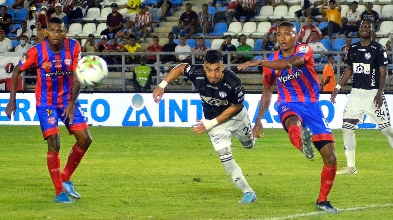 Fernando Uribe disputa el balón con un defensa samario. 
