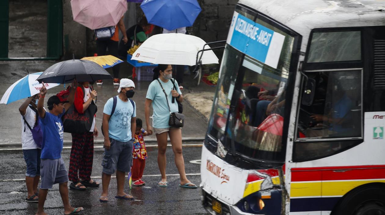 Ciudadanos de protegen de las lluvias con paraguas.