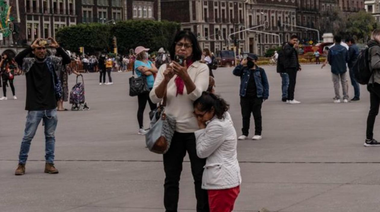 Una mujer se arrodilla en pleno centro de Ciudad de México durante el sismo de este lune