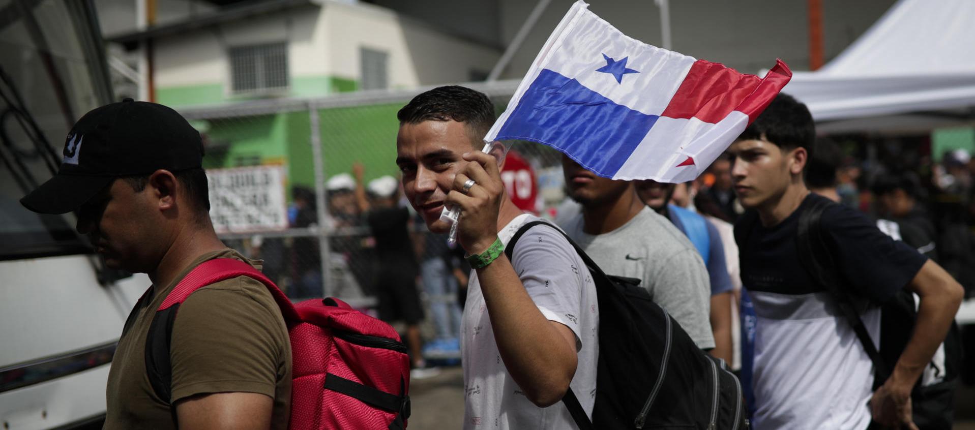 Migrantes de origen venezolano hacen fila para subir a un autobús hacia el aeropuerto internacional de Tocumen en Ciudad de Panamá