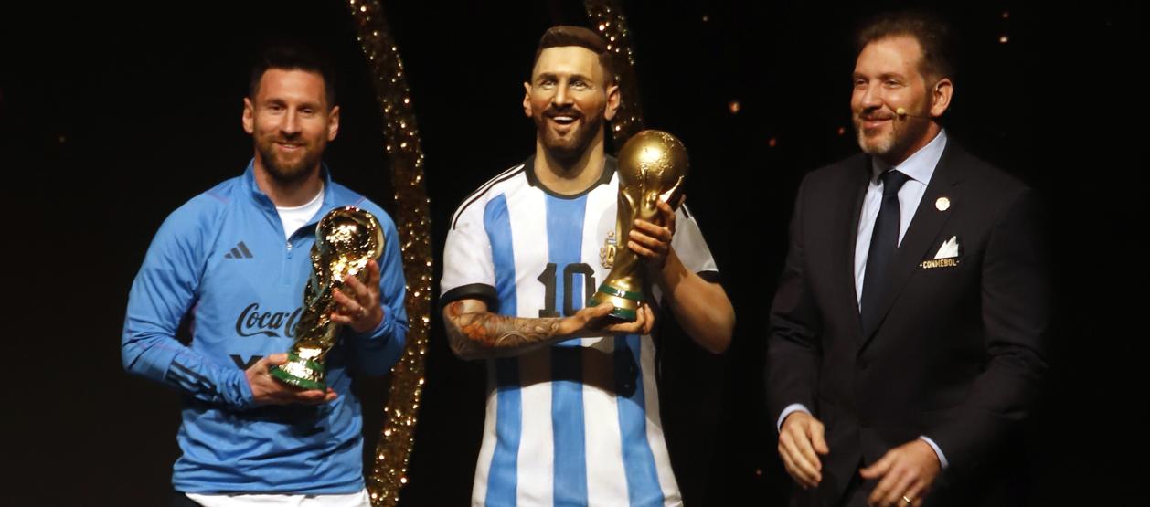 Lionel Messi, al lado de su estatua y de Alejandro Domínguez, presidente de la Conmebol.