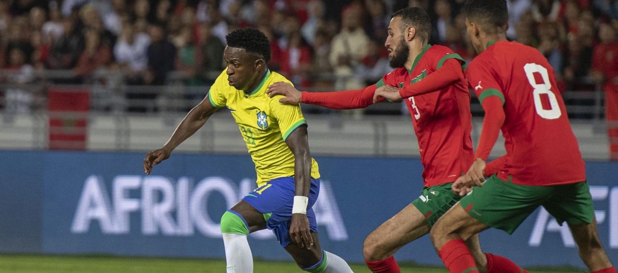 Vinicius Junior avanza ante la presión de dos jugadores marroquíes.