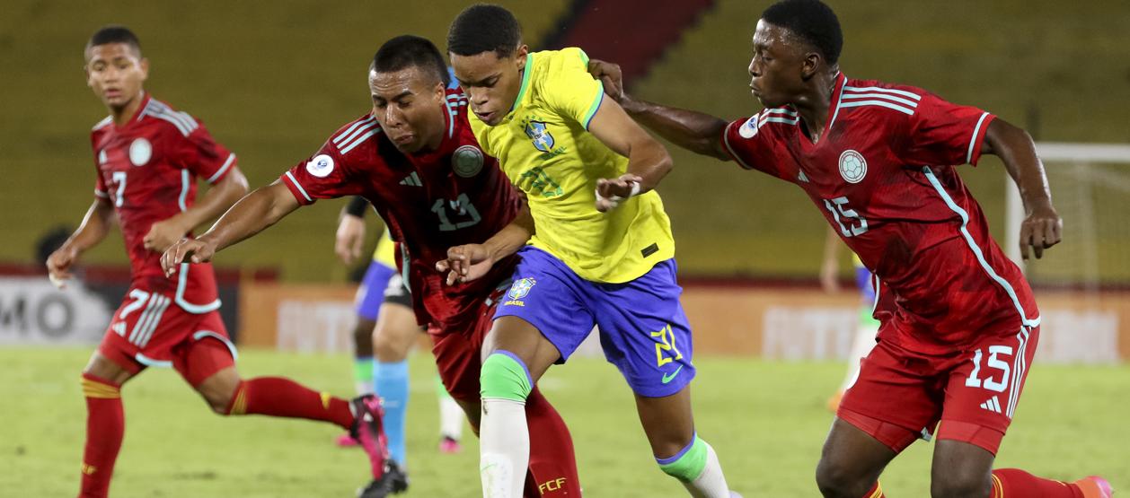 El brasileño Matheus avanza ante la marca de dos jugadores colombianos.