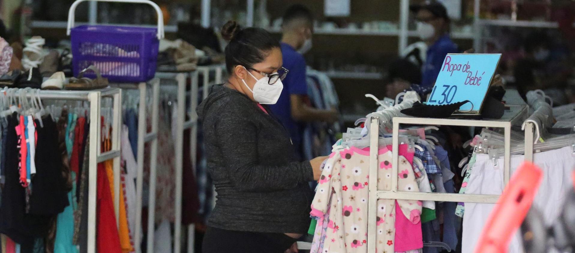 Una mujer realiza compras en una tienda de ropa usada en Tegucigalpa