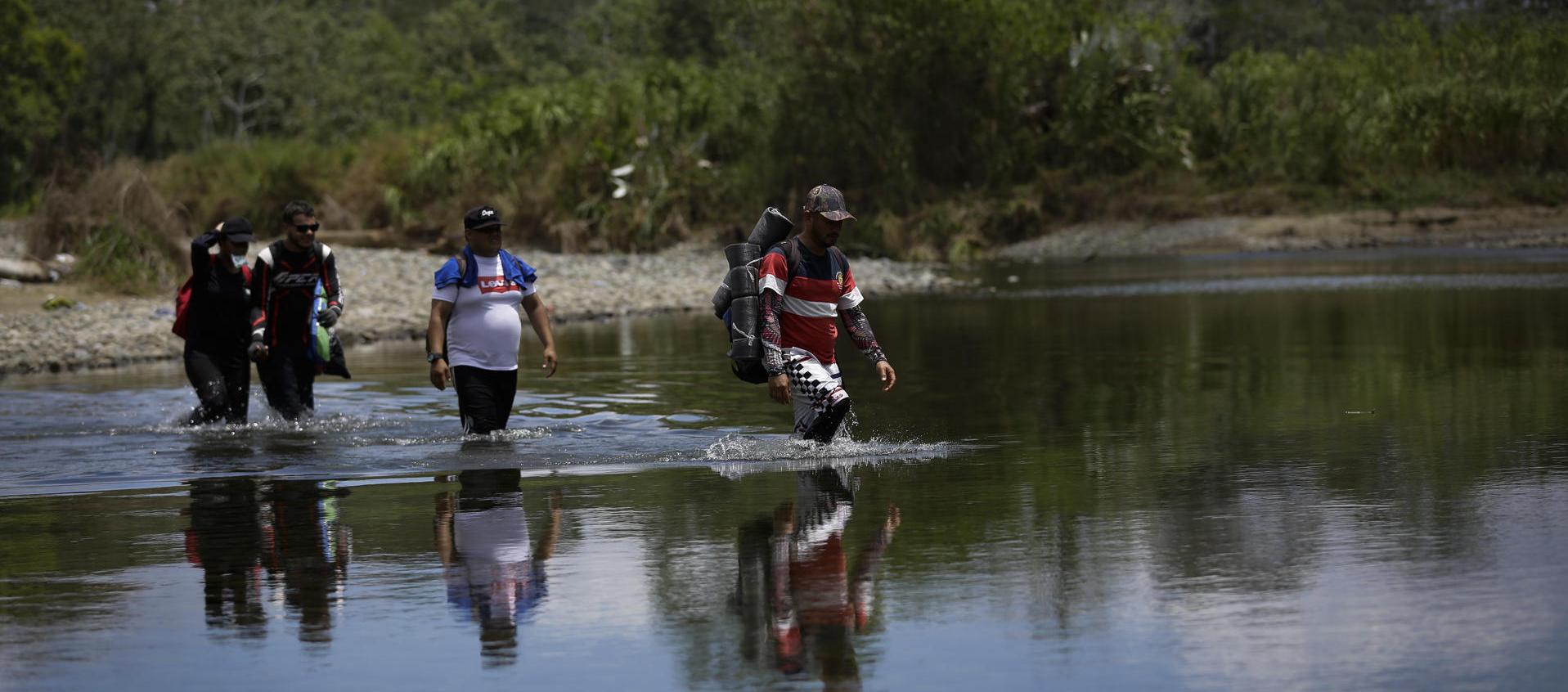Personas migrantes cruzan el río Tuquesa, en Darién (Panamá), en una fotografía de archivo. 