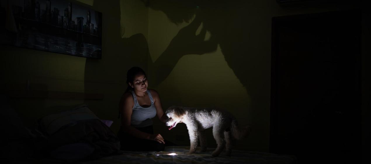 Una mujer usa la lámpara de su celular tras la falta de energía en Venezuela.