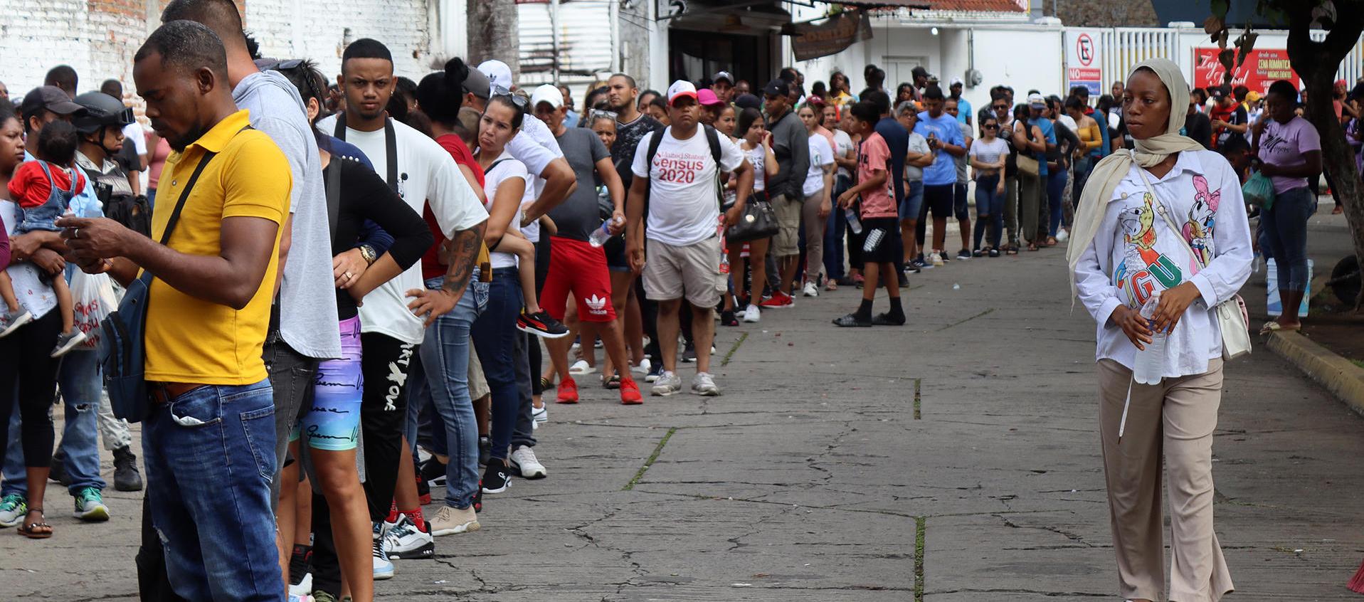 Migrantes hacen fila en espera de regularizar su documentación en el municipio de Tapachula, en el estado de Chiapas