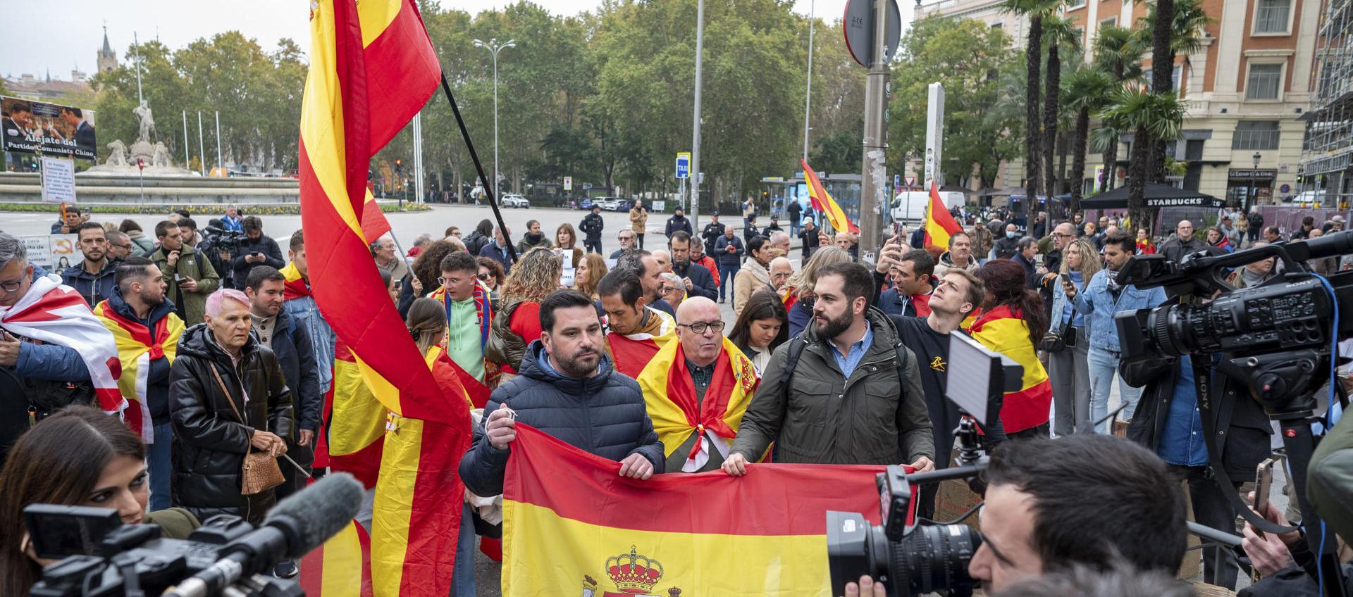 Varias personas con banderas de España protestan en las inmediaciones del Congreso de los Diputados