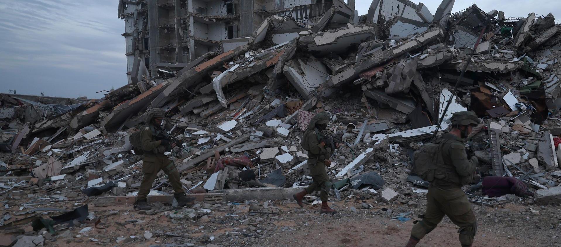 Foto de archivo de unos soldados israelíes caminando entre los escombros de edificios destruidos en la localidad palestina de Beit Lahia