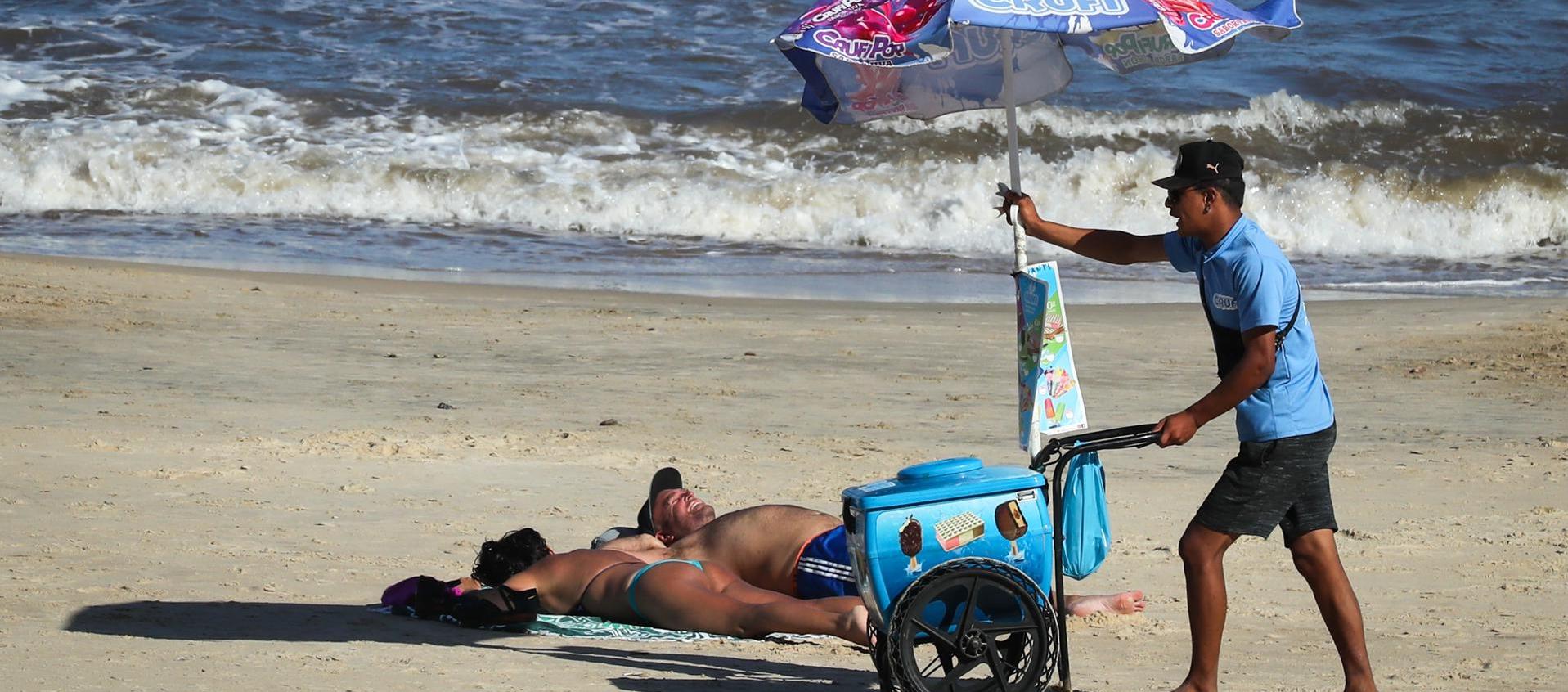 Un hombre vende helados en la Playa Pocitos de Montevideo durante una ola de calor.