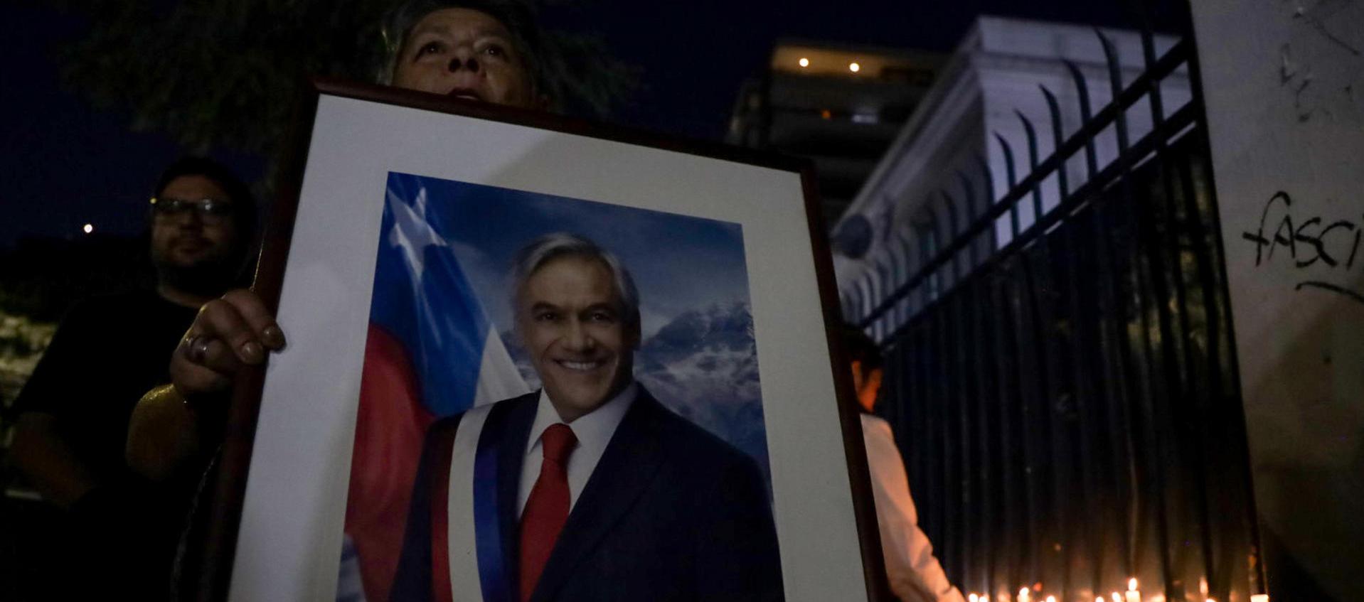 Militantes de Renovacion Nacional encienden velas en la sede del partido en apoyo al falecido expresidente de Chile Sebastían Piñera